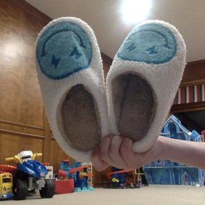 Blue lighting bolt smiley face slippers.